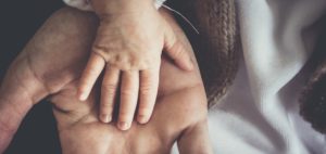 Baby's hand over mother's hand