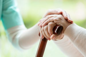 Nurse holding an elderly patient's hand