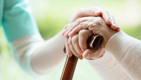 Nurse holding an elderly patient's hand